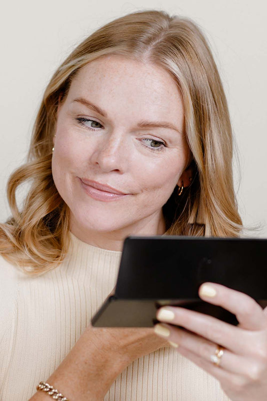 Leonie Scholl hält die JACKS beauty line Face Palette vor sich und schminkt sich