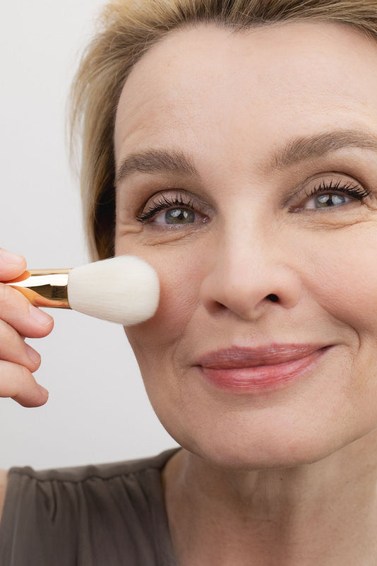 #farbwunsch_neon, #farbwunsch_nature-colors, #farbwunsch_monochrom, Susann Atwell hält den JACKS beauty line Präzisen Puderpinsel an die Wange