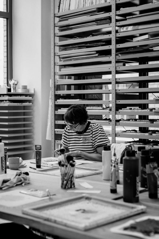 Eine Kundin sitzt im Belriner Pinselatelier und bemalt ihren eigenen Make-up Pinsel