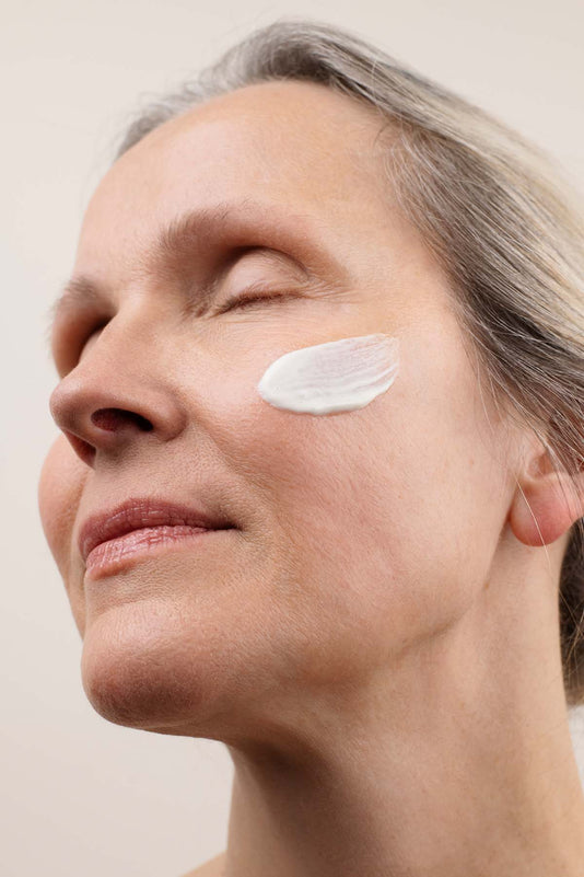 Frau Ü50 hat einen Swatch der JACKS beauty line Tagescreme auf der Wange