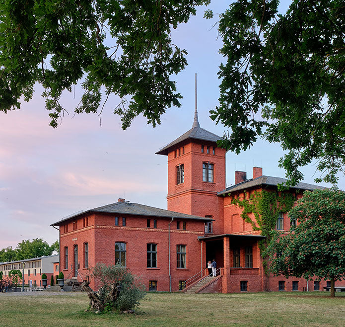 Rotes Backstein Gebäude umgeben von Wiese