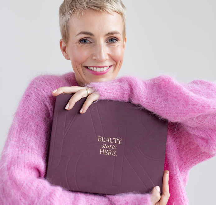 Miriam Jacks im pinken Pullover hält den JACKS beauty line Adventskalender 2025 in den Händen