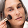 Frau trägt die JACKS beauty line Glow Foundation mit dem #12 Foundationpinsel auf