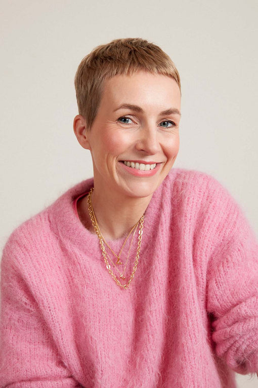 JACKS beauty line Gründerin Miram Jacks trägt einen pinken Pullover und lächelt