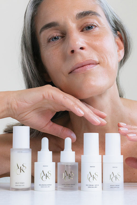 5 JACKS beauty line Reisegröße Skincare Produkte stehen auf einem Tisch vor einer Frau