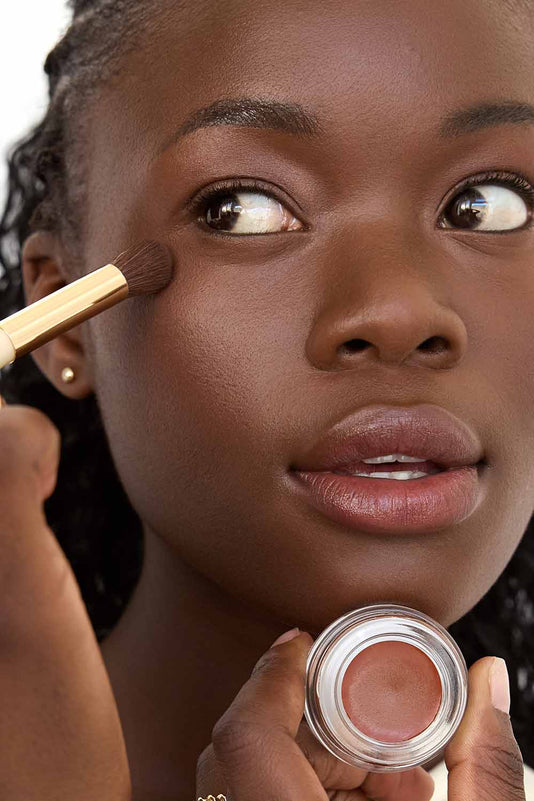 #farbwunsch_n-9, Schwarze Frau hält den JACKS beauty line Cover Concealer N9 vor ihr Gesicht