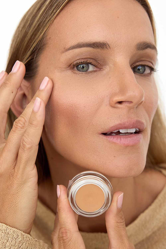 #farbwunsch_n-4, Frau trägt Cover Concealer N4 und hält Concealer Tiegel vor ihr Gesicht