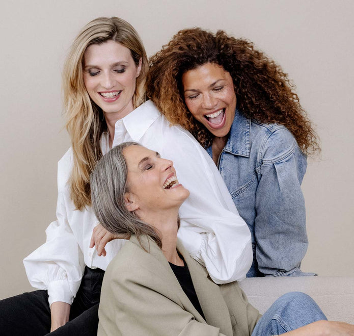 Drei Frauen unterschiedlichen Alters lachen gemeinsam