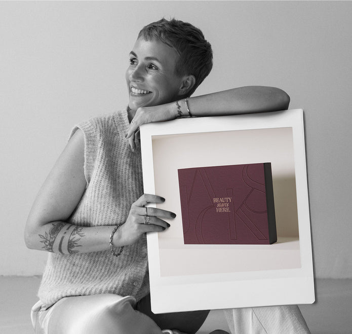 Miriam Jacks lehnt sich an ein Polaroid Bild mit der Abbildung des JACKS Adventskalender 2025