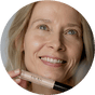 Blonde Frau Ü50 hält den JACKS beauty line Cream Concealer vor ihr Gesicht Blonde Frau Ü50 hält den JACKS beauty line Cream Concealer vor ihr Gesicht