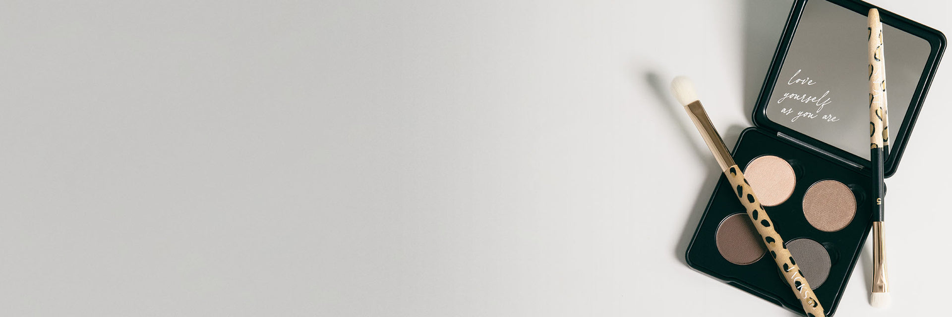 2 JACKS beauty line Lidschattenpinsel liegen auf einer 4er Lidschattenpalette