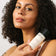 Frau mit dunkelbraunen Locken hält den JACKS beauty line Milky Toner in den Händen