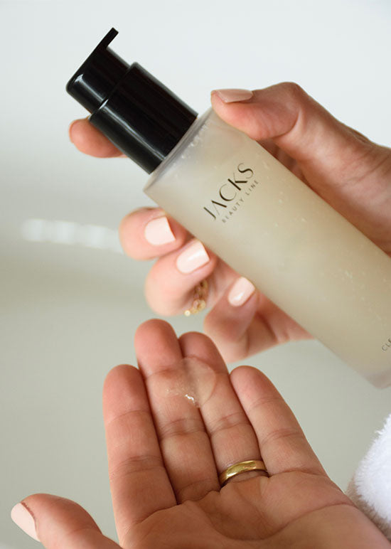 Linke Hand hat einen Kleks JACKS beauty line Cleanser in der Hand und rechte hält die Flasche
