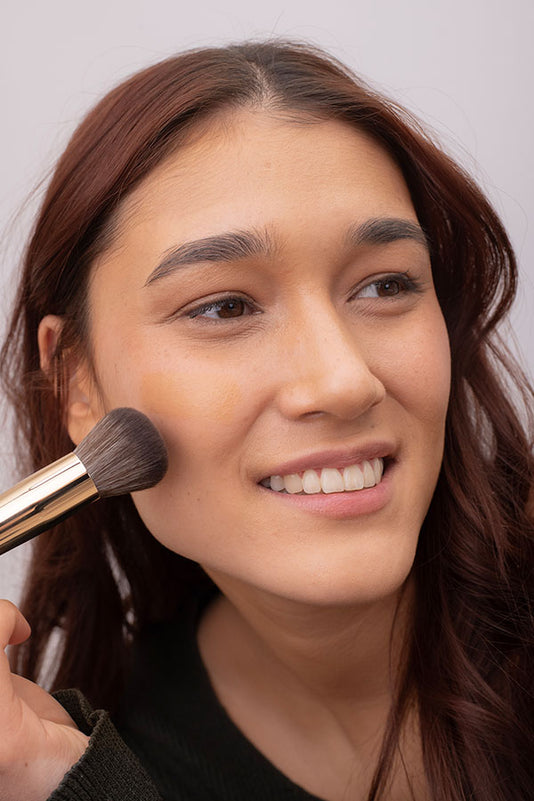 #farbwunsch_n-5, Frau mit JACKS beauty line Cover Foundation N.5 und #12 Foundationpinsel in der Hand