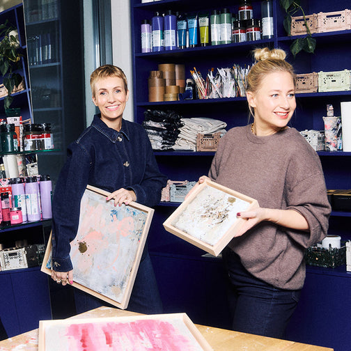 Miriam Jacks und Lisa Buchholz halten farbige Leinwände Miriam Jacks und Lisa Buchholz halten farbige Leinwände