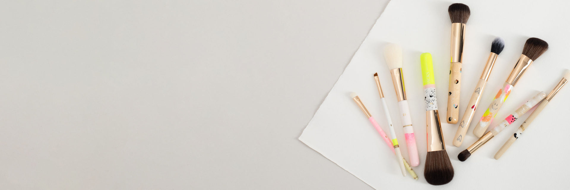 9 nebeneinanderliegende bunte handbemalte Make-up Pinsel