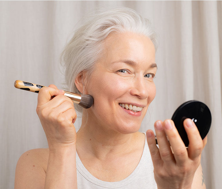 Frau hält JACKS beauty line #12 Foundationpinsel und Puder in der Hand Frau hält JACKS beauty line #12 Foundationpinsel und Puder in der Hand