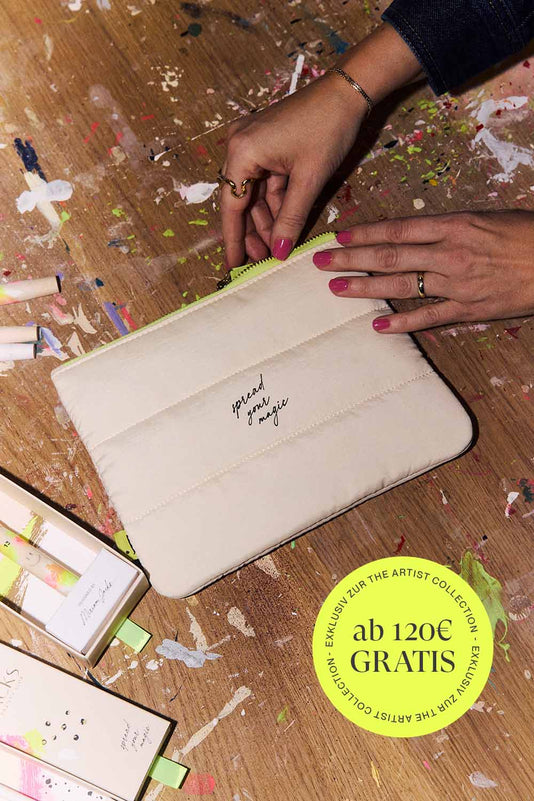 Beige Make-up Tasche mit Neongelben Reißverschluss auf einem Tisch mit Farbe