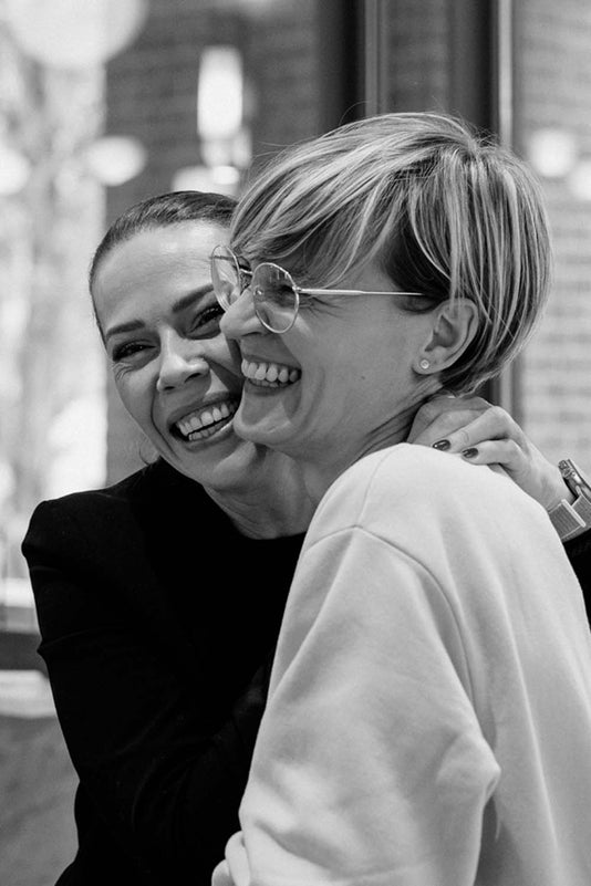 Zwei Frauen lächeln intensiv und umarmen sich