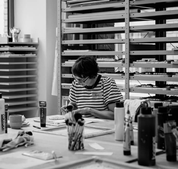 Frau bemalt einen Make-up Pinsel von Hand im Berliner Atelier