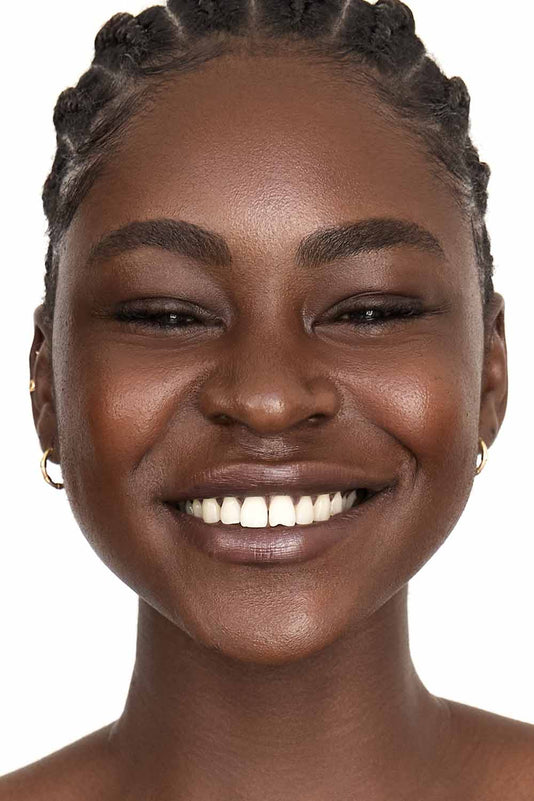 #farbwunsch_n-10, #farbwunsch_mittlerer-bis-dunkler-hauttyp, Schwarze Frau mit Braids lächelt