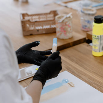 Frau bemalt Make-up Pinsel Rohlinge mit ihren Fingern in hellblau und weiß Frau bemalt Make-up Pinsel Rohlinge mit ihren Fingern in hellblau und weiß