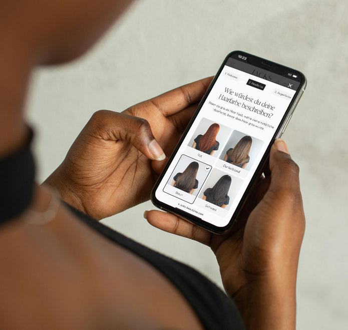 Frau hält ein Smartphone in der Hand und führt die JACKS beauty line Farbberatung durch
