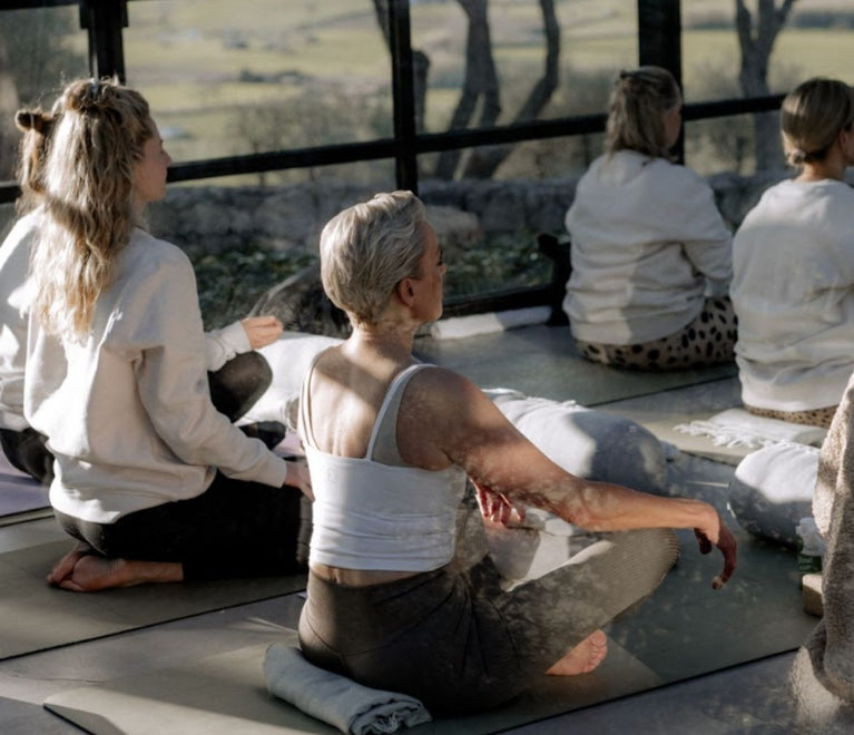 Mehrere Frauen sitzen auf Yogamatten