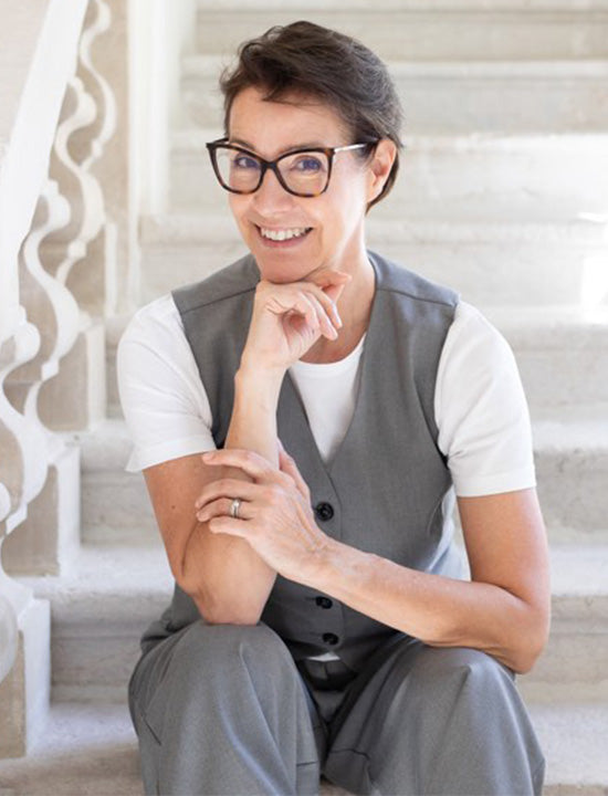 Anja Frankenhäuser sitzt im Hosenanzug auf einer Treppe