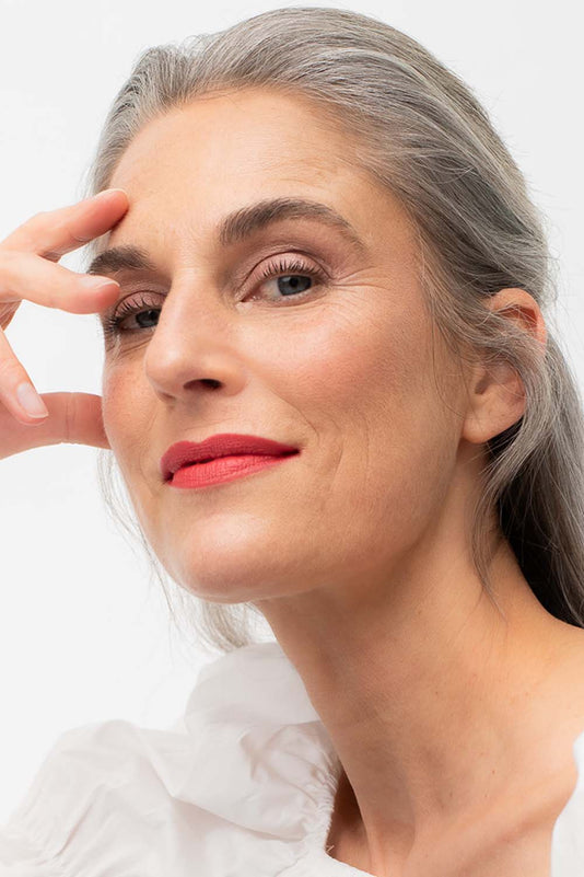 #farbwunsch_coral, Grau-braunhaarige Frau trägt den JACKS beauty line Lipstick in Coral