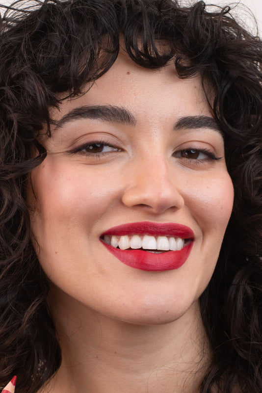 #farbwunsch_signature-red, Braunhaarige Frau trägt den JACKS beauty line Lipstick in Signature Red