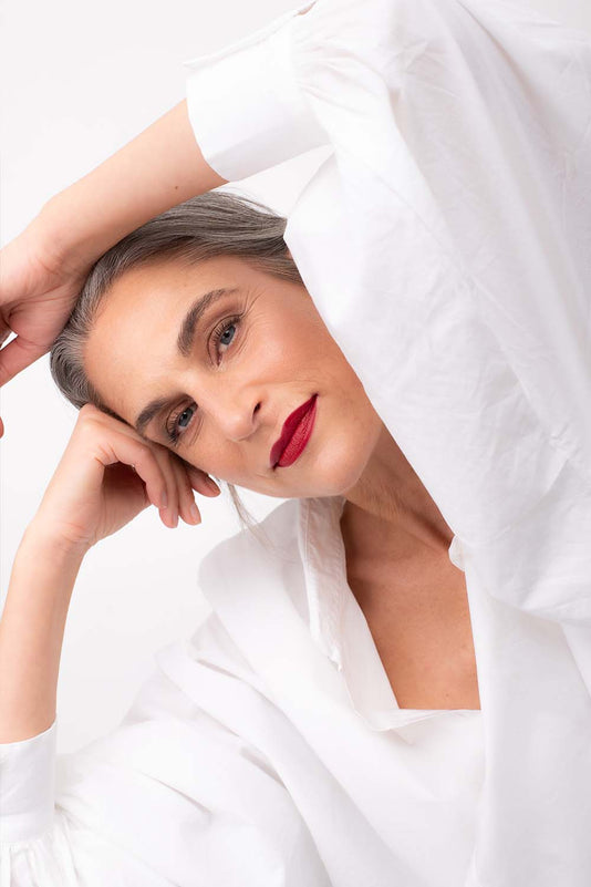 #farbwunsch_signature-red, Grau-braunhaarige Frau trägt den JACKS beauty line Lipstick in Signature Red