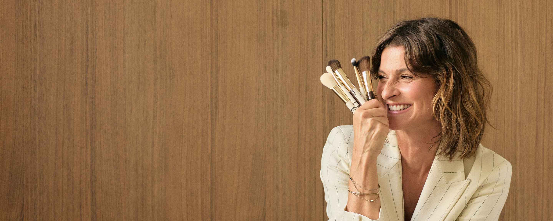 Marlene Lufen hält lächelnd JACKS Pinsel ihrer Artist Collection neben ihr Gesicht