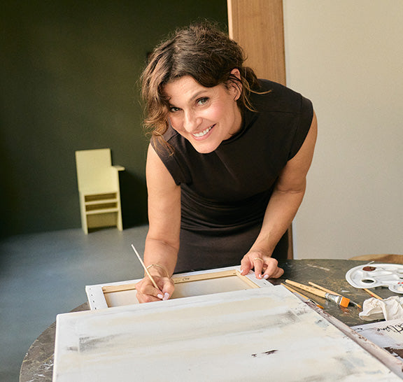 Marlene Lufen unterschreibt hinten auf einer bemalten Leinwand