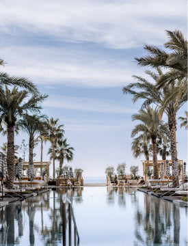 Pool am Strand mit Palmen und blauem Himmel