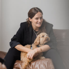 braunhaarige Frau auf der Couch mit Pudel im Arm braunhaarige Frau auf der Couch mit Pudel im Arm