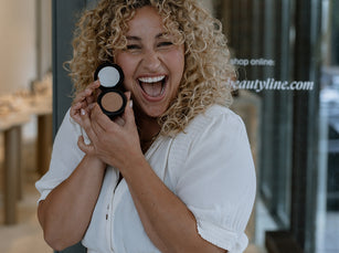 Blonde Frau lächelt und hält den JACKS beauty line Glow Bronzer neben ihr Gesicht