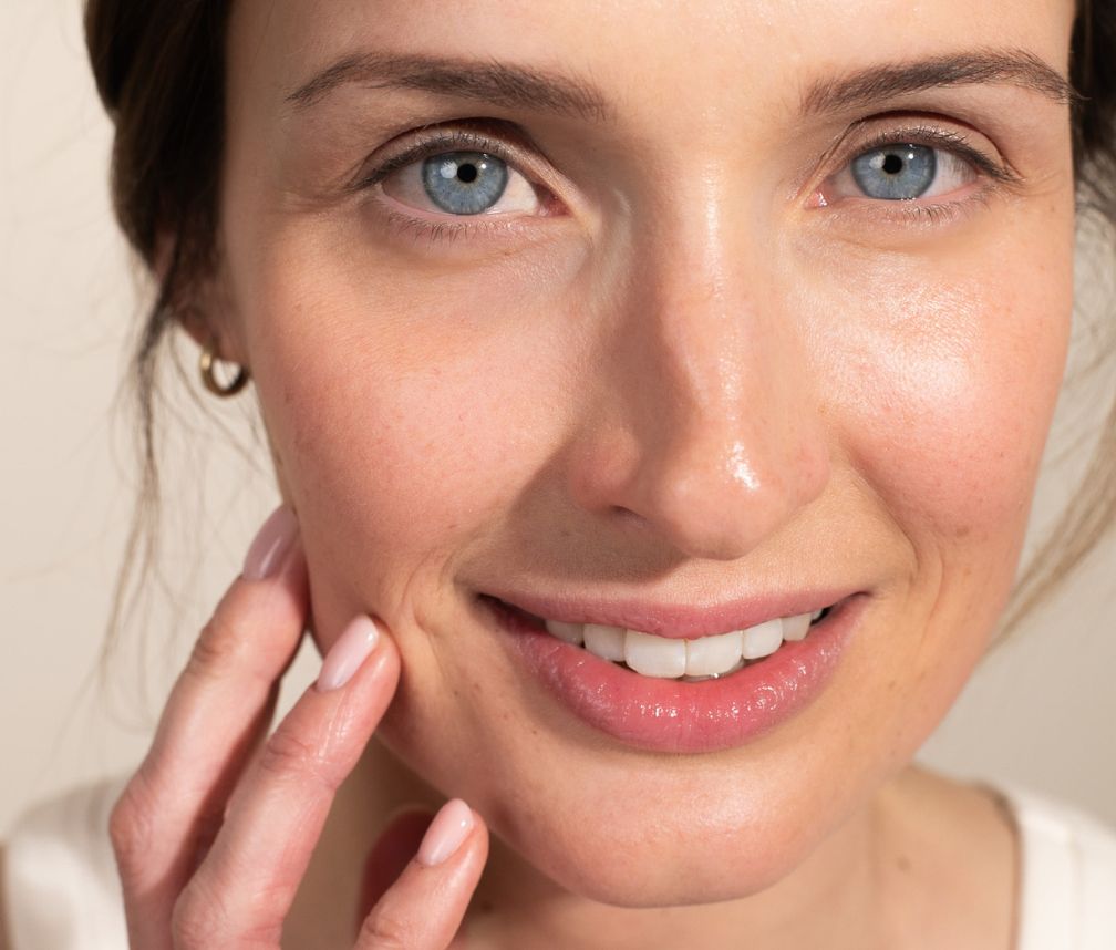 Close-up von einer braunhaarigen Frau mit blauen Augen und strahlender Haut Close-up von einer braunhaarigen Frau mit blauen Augen und strahlender Haut