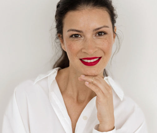 Braunhaarige Frau trägt roten Lippenstift auf den Lippen