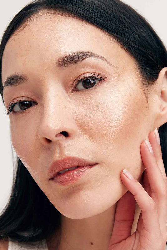 schwarzhaarige Frau trägt den JACKS beauty line Cream Highlighter auf den Wangen