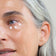 Eine Frau Ü50 hat 3 Punkte Augencreme unter ihrem Auge