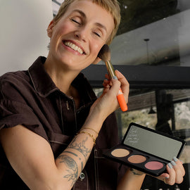 Miriam Jacks hält die Individual Powder Palette und trägt sich Blush mit dem Puderpinsel auf