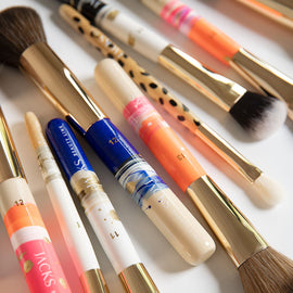 Viele verschieden handbemalte JACKS beauty line Make-up Pinsel liegen auf einem Tisch
