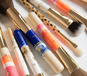 Viele verschieden handbemalte JACKS beauty line Make-up Pinsel liegen auf einem Tisch