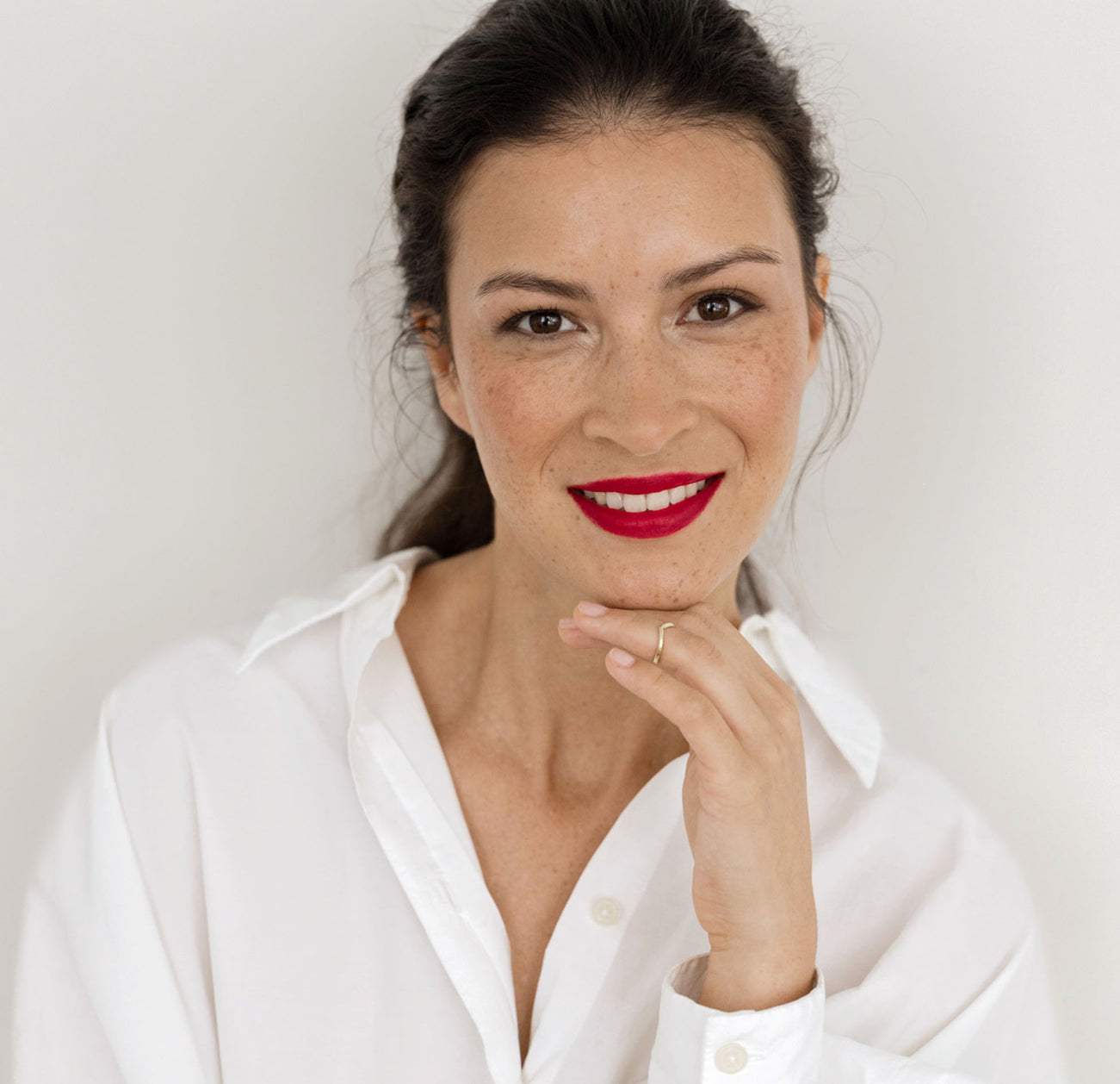 Frau mit braunen Haaren trägt den JACKS beauty line roten Lippenstift auf den Lippen