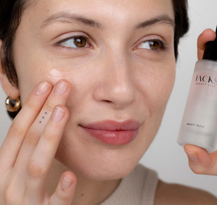Junge Frau trägt das JACKS beauty line Beauty Elixir mit den Händen auf das Gesicht auf