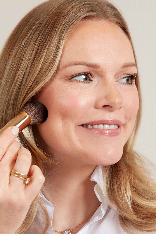 Frau trägt die JACKS beauty line Glow Foundation mit dem #12 Foundationpinsel auf