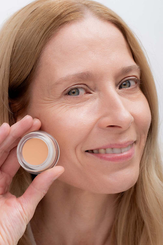 #farbwunsch_n-3, Frau trägt Cover Concealer Farbe N.3 und hält Concealer Tiegel in der Hand