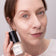 #farbwunsch_n-1, Frau mit JACKS beauty line Cover Foundation N.1 Swatch im Gesicht und Flakon in der Hand