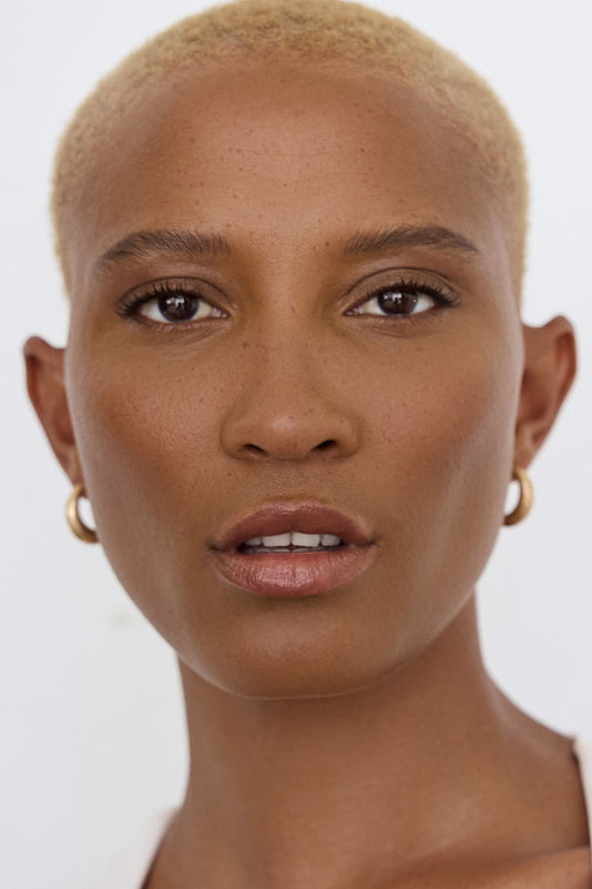 #farbwunsch_n-7, Porträt einer Schwarzen Frau mit kurzem blonden Afro und natürlichem Make-up